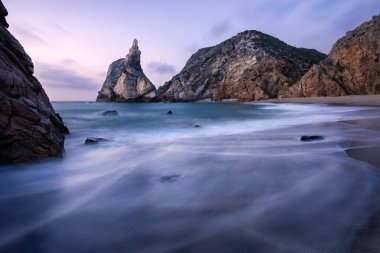 Efsanevi Ursa Sahili, Sintra, Portekiz. Dalgalarla dolu bir sahil ve akşamüstü yumuşak günbatımı ışığında kayaların zirvesi. Atlantik Okyanusu manzarası