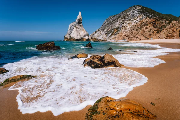 Praia de Portugal Ursa na costa atlântica do oceano. Onda espumosa na praia de areia com rocha surreal jugged no fundo paisagem pitoresca litoral — Fotografia de Stock