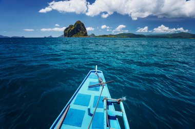 El Nido, Palawan, Filipinler. Muhteşem Pinagbuyatan Adası 'na giden geleneksel banca teknesi. Kocaman kireçtaşı kayalıkları ve hindistan cevizi palmiyeli şirin Ipil plajı olan küçük dairesel bir ada.