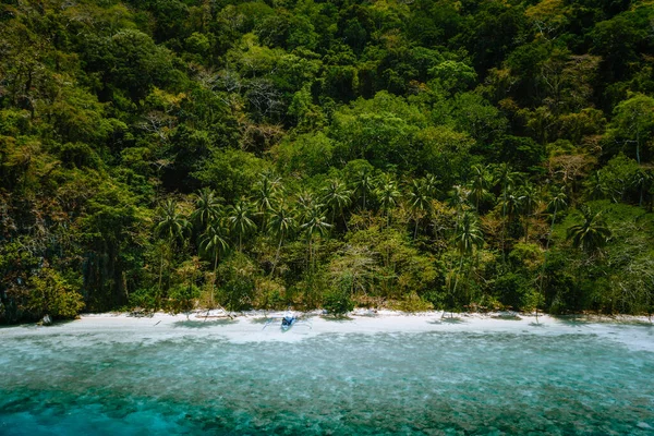 菲律宾巴拉旺，El Nido 。 在令人印象深刻的热带雨林丛林的霜冻中，空中无人驾驶飞机俯瞰着一个荒凉的荒凉的热带海滩和孤独的旅游船 — 图库照片