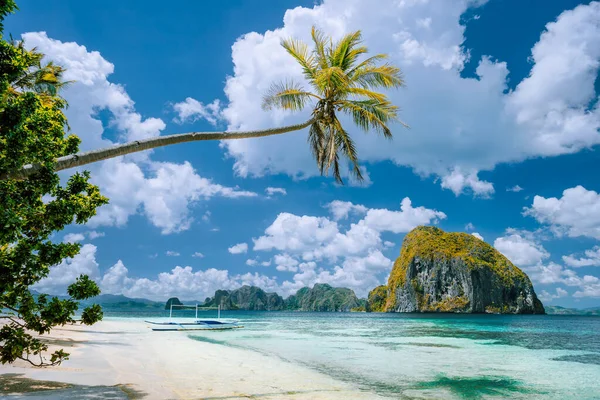 El Nido, Palawan, Filipíny. Tropická scenérie exotické pláže s palmami, loď na písečné pláži a modrá obloha s bílými mraky v pozadí — Stock fotografie