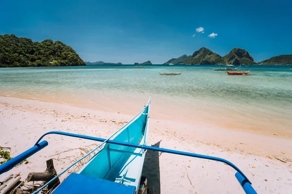 Mavi lagünün önündeki Las Cabanas plajında geleneksel banka teknesi ve El Nido, Palawan, Filipinler 'deki egzotik doğa manzarası. — Stok fotoğraf