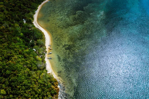 Palawan, Philippines, El Nido. Aerial drone above view of a secluded deserted tropical beach with local traditional boats on coastline in front of rainforest jungle — Stock Photo, Image