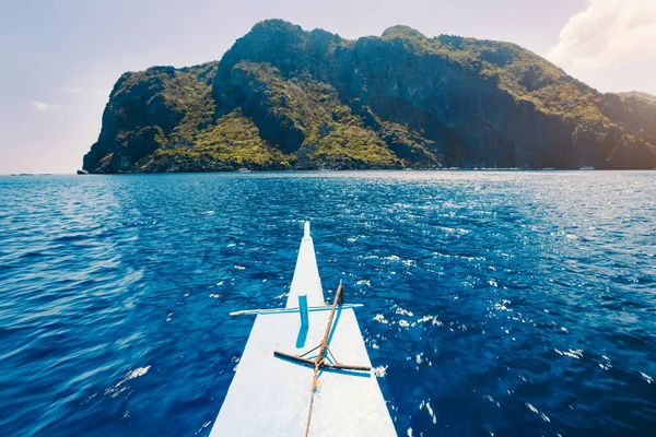El Nido, Filipiny. Przód wyspy hopping Tour łódź unosi się nad otwartym błękitnym oceanie wody stoi egzotyczne krasowej wyspie wapiennej na wycieczkę — Zdjęcie stockowe