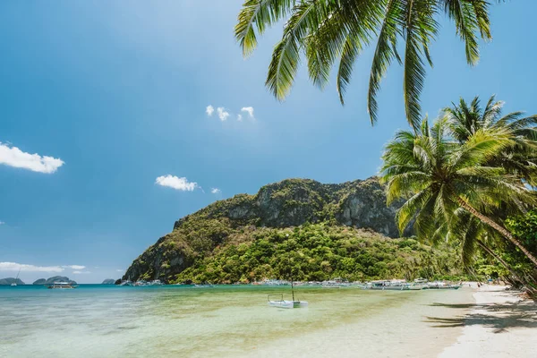Palmy a krásné scenérie Corong Corong pláž s tradičními čluny, horské a modré nebe v El Nido, Palawan ostrov, Filipíny — Stock fotografie
