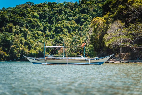 Csónak a víz felszínén El Nido öbölben dzsungellel a háttérben, Palawan, Fülöp-szigetek — Stock Fotó