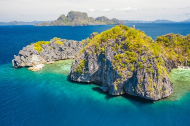 Yukarıdan bakıldığında, turkuaz, kristal berrak deniz ile çevrili bilinmeyen bir adanın havadan görünüşü. Bacuit Körfezi, El Nido, Palawan, Filipinler