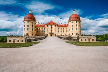 Moritzburg Şatosu Almanya 'da, Saksonya bölgesinde, Dresden yakınlarında. Mavi gökyüzü ve beyaz bulutlarla güzel bir bahar günü. Etrafı güzel parklarla çevrili.
