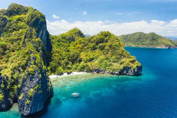 Aerial drone view of tropical beach with lonely boat on Entalula Island. Karst limestone formation mountain surrounded by blue ocean and beautiful coral reef — Stock Photo, Image