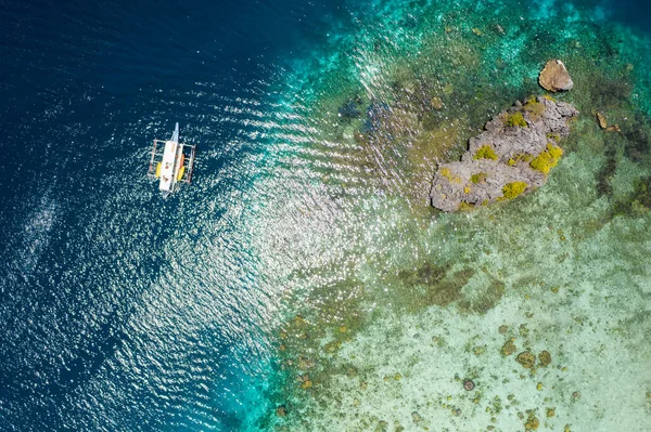 Shimizu sziget, El Nido, Palawan, Fülöp-szigetek. Gyönyörű felülről lefelé légi kilátás magányos ugróhajó sekély lagúna és korallzátony — Stock Fotó