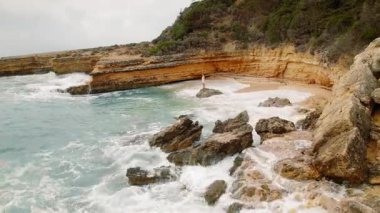 Yunanistan 'ın Kefalonya kıyısındaki ıssız bir koyda kayalık bir sahilde duran kadın.