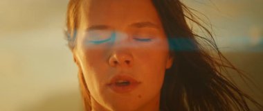 Gün batımında deniz kenarında meditasyon yapan bir kadın..