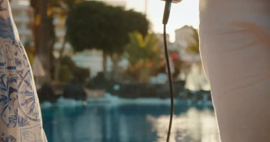 Günbatımında havuz kenarında sahne alan müzik sanatçılarının kablo ve kıyafetleri..