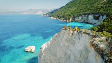 Kefalonia 'da turkuaz sulara bakan beyaz uçurumun kenarında duran bir kadın..