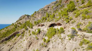 Çam ormanlarını geçen dağ yürüyüşçüleri Kefalonia kayalıklarındaki Assos Kalesi 'ne gider..