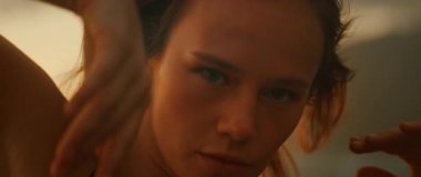 Odaklanmış dansçı, açık havada dramatik ışıklandırma ile dans gösterisi sırasında kameraya bakar..