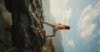 Okyanus manzaralı mavi gökyüzünün altında çıplak ayakla dans eden bir kadın..