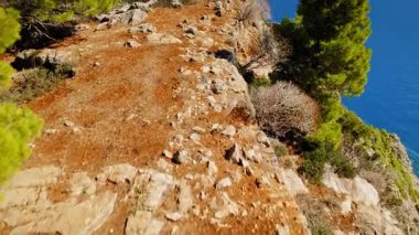 Yunanistan 'da Kefalonia' da dağ ve deniz manzaralı engebeli patika boyunca koşan kadın.