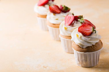 Sarı arka planda çilekli cupcakes