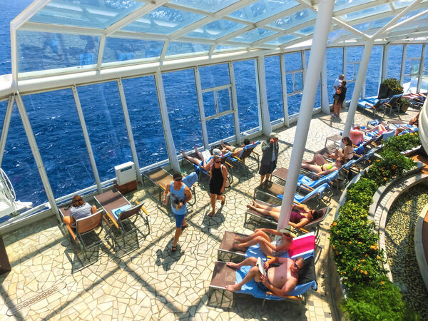 Cape Canaveral, USA - April 30, 2018: The people resting at sea Solarium on the Royal Carribean cruise ship Oasis of the Seas
