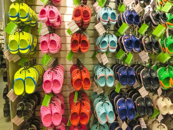 Tampa, USA - May 10, 2018: Rack with lots of pairs of childrens soft rubber sandals or Crocs in various pink, blue, green and black colours — Stock Photo, Image