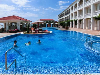 Berdyansk, Ukrayna 30 Haziran 2018: Sun Resort otel Azak Denizi Plajı'nda yüzme havuzunda dinlenme insanlar