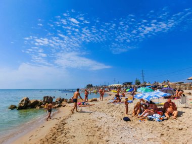 Berdyansk, Ukrayna 30 Haziran 2018: beach resort seasonon Azak Denizi'nin kıyısında. İnsanlar plajda güneşlenirken.