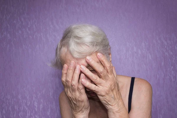 Ritratto di una donna anziana con il volto chiuso a mano — Foto Stock