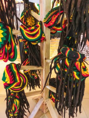 many hats with the colors of the Jamaican flag for sale in the costume shop clipart