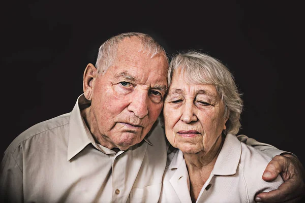 伤心的老年夫妇，在黑色的背景 — 图库照片