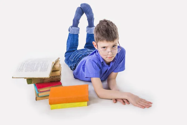 Retrato de colegial lindo sentado con libros y mecanografía en el teclado del ordenador portátil — Foto de Stock