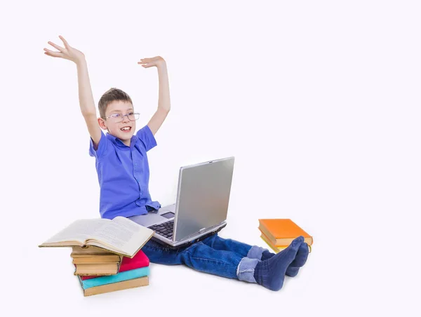 Retrato de colegial lindo sentado con libros y mecanografía en el teclado del ordenador portátil — Foto de Stock