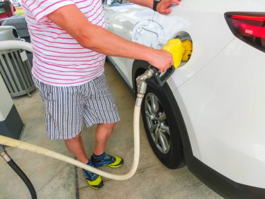 Araba benzin istasyonunda yakıt ikmali. Yakıt pompası benzin ile.