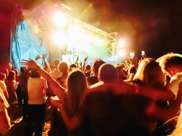 Menigte verhogen hun handen en genieten van groot festival feest of concert. — Stockfoto
