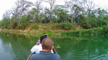 Kimliği belirsiz kişi Safari ahşap tekne Pirogues Chitwan Milli Parkı'nda Rapti nehrinde kano