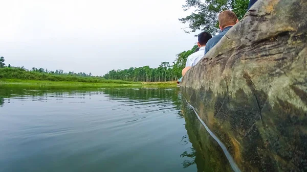 Unbekannte paddeln auf Holzbooten auf dem Rapti-Fluss im Chitwan-Nationalpark — Stockfoto