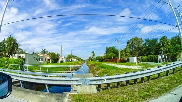 Typical Florida home in the countryside with palm trees, tropical plants and flowers