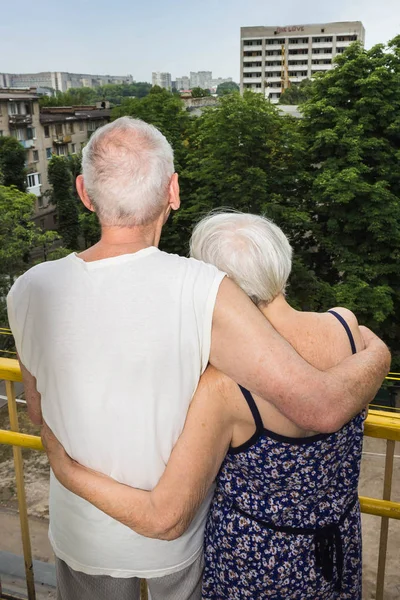 Casal sênior de pé oustide na varanda em casa e olhando para longe — Fotografia de Stock