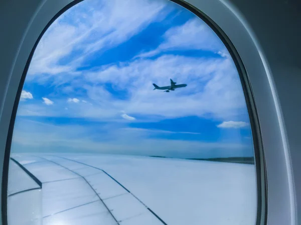 Vista desde un avión sobre un cielo azul y nubes blancas. Volando en el avión . — Foto de Stock