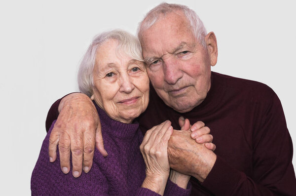 Sad elderly couple on a gray background