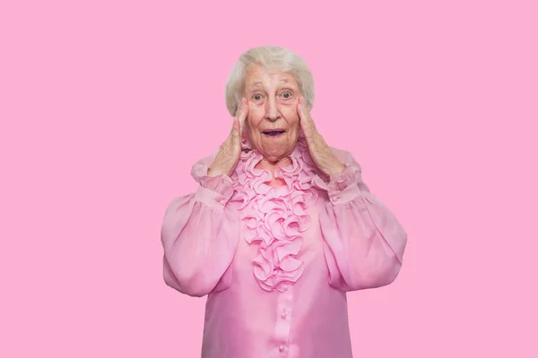 Porträtt av en förvånad senior kvinna över rosa bakgrund — Stockfoto