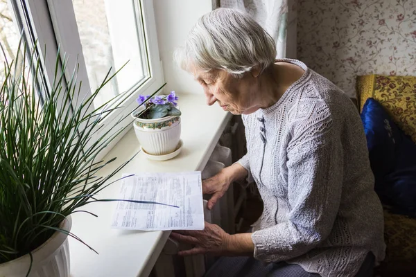 Woman holding cash in front of heating radiator. Payment for heating in winter. Selective focus. — Stock Photo, Image