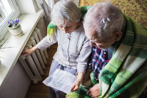 Vrouw met contant geld voor de verwarming van de radiator. Betaling voor verwarming in de winter. Selectieve aandacht. — Stockfoto