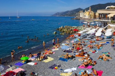 Camogli, İtalya - 15 Eylül 2019: Güneşli yaz gününde insanlar Camogli plajında dinleniyor
