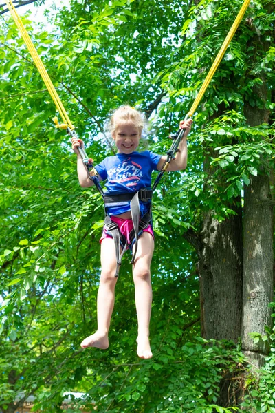 Das Lächelnde Fröhliche Mädchen Springt Mit Bungee Trampolin Park Gegen — Stockfoto