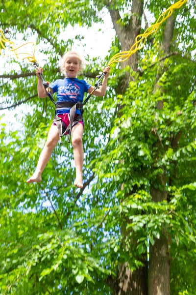 Das Lächelnde Fröhliche Mädchen Springt Mit Bungee Trampolin Park Gegen — Stockfoto