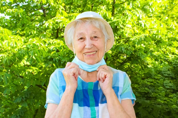 Mulher Sênior Sorrindo Positiva Tira Máscara Médica Protetora Cara Livre — Fotografia de Stock