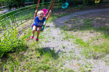 Yaz kavramı. Atlıkarıncadaki parkta eğlenen kız.