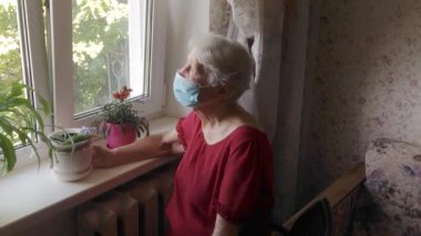 Olumlu gülümseyen son sınıf öğrencisi kadın koruyucu tıbbi maskeyi evde yüzünden çıkarıyor. Mutlu son ya da Coronavirus 'a karşı zafer kavramı. Salgın Covid-19.