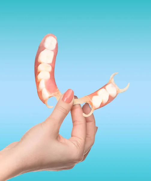 柔韧的尼龙假牙在女性手上 可摘除的义齿柔韧 无尼龙 低过敏性 不含单体 — 图库照片